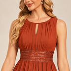 Rust orange keyhole neck and pleated bodice detail of the A-line evening gown.
