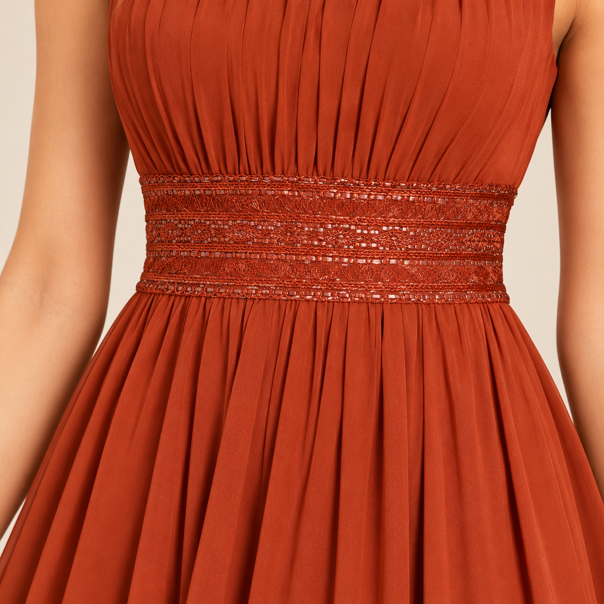 Rust orange evening gown decorative waistband and pleated chiffon skirt detail.